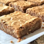 Delicious blonde brownies served on a plate with a drizzle of caramel.