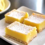 Delicious gluten free lemon bars topped with powdered sugar on a plate