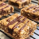 Delicious healthy peanut butter chunk oatmeal bars stacked on a plate.