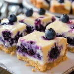 Delicious lemon blueberry cheesecake bars on a white plate