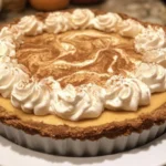Delicious pumpkin cheesecake pie topped with whipped cream