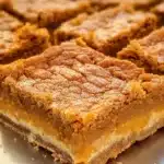 Delicious pumpkin pie bars served on a plate with whipped cream