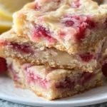 Freshly baked strawberry lemon blondies with bright pink strawberries and lemon zest
