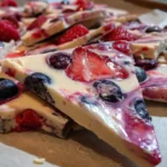Homemade berry yogurt bark topped with fresh berries and yogurt