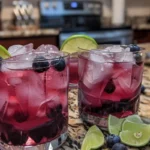 Refreshing Blueberry Gin & Tonic cocktail with fresh blueberries and mint garnish.
