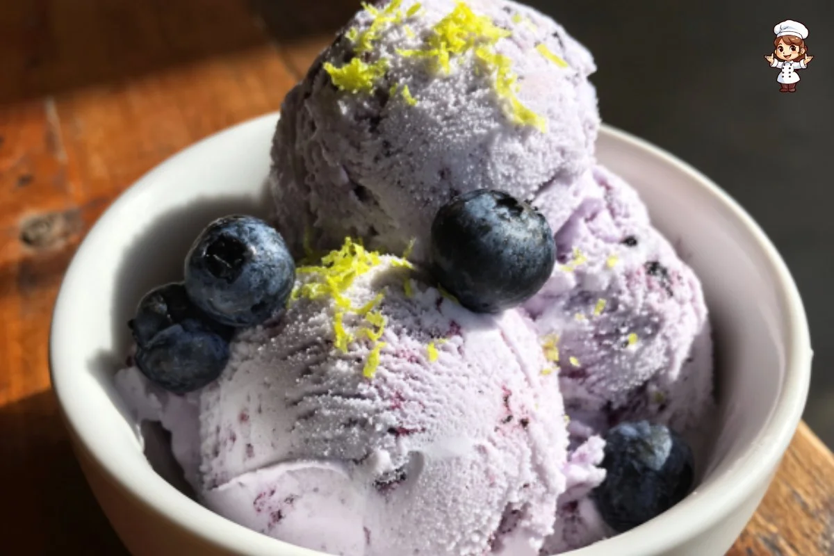 Delicious homemade blueberry ice cream served in a bowl with fresh blueberries.