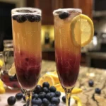 Glass of blueberry lemosas with fresh blueberries garnishing the drink