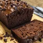 Loaf of double chocolate banana bread sliced on a wooden board