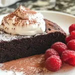 Flourless chocolate cake served on a white plate with berries