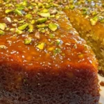 Fragrant pistachio almond cake topped with orange zest for a delicious dessert.