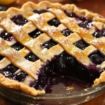 Homemade blueberry pie fresh from the oven with golden crust and blueberries
