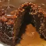 Moist Date Cake topped with creamy Buttery Toffee Glaze on a white plate.