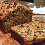 Moist peanut butter chocolate chip zucchini bread sliced on a wooden board