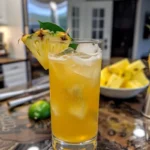 Pineapple Rum cocktail garnished with a slice of pineapple and mint leaves.