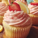 Delicious pink lemonade cupcakes topped with frosting and lemon slices.