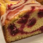 Delicious Raspberry Swirl Pound Cake with bright red raspberry swirls on a gold plate.