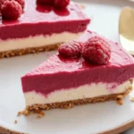 Delicious raspberry vegan cheesecake on a white plate with fresh berries