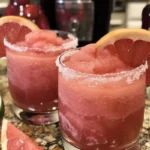 Refreshing ruby red grapefruit tequila slushie in a glass on a summer day.