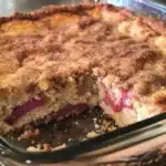 Sour cream rhubarb coffee cake served on a plate with a slice cut out