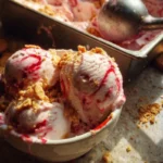 Homemade strawberry cashew ice cream served in a bowl with fresh strawberries