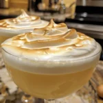 A refreshing Swiss Meringue cocktail garnished with mint and berries.