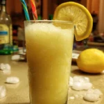 Delicious lemon slush in a clear glass garnished with a lemon slice