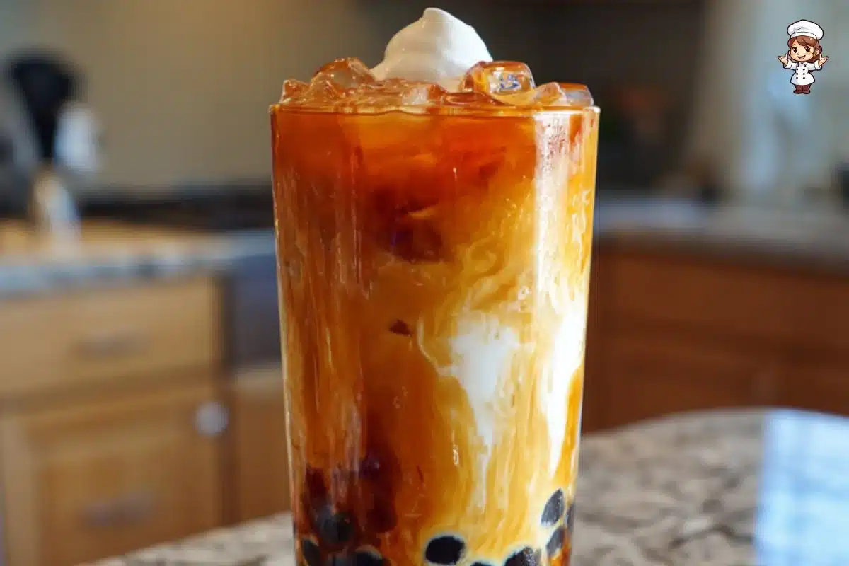 A refreshing cup of Thai milk tea boba with tapioca pearls, served in a clear glass.